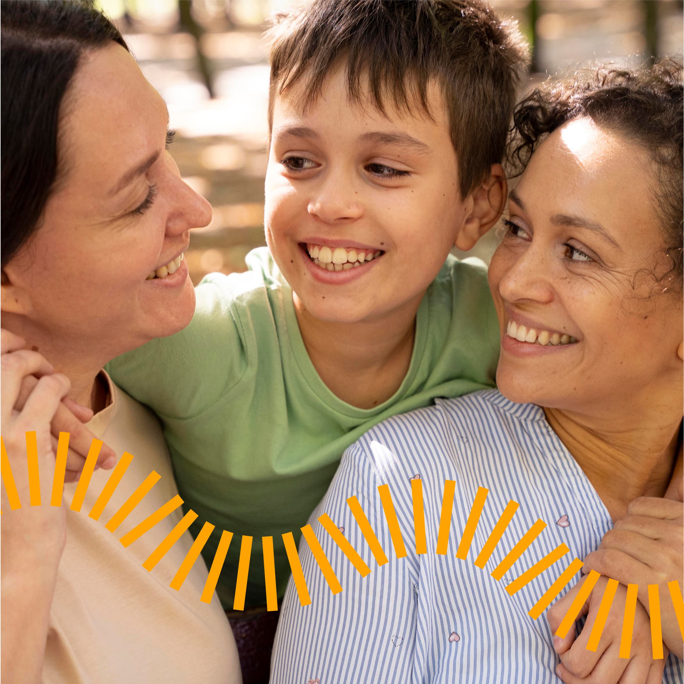 A warm, intimate family portrait showing three smiling people in close embrace, with a child in a mint green hoodie centered between two adults in light-colored clothing. The image features decorative yellow sun ray graphics along the bottom, creating a joyful, radiant atmosphere