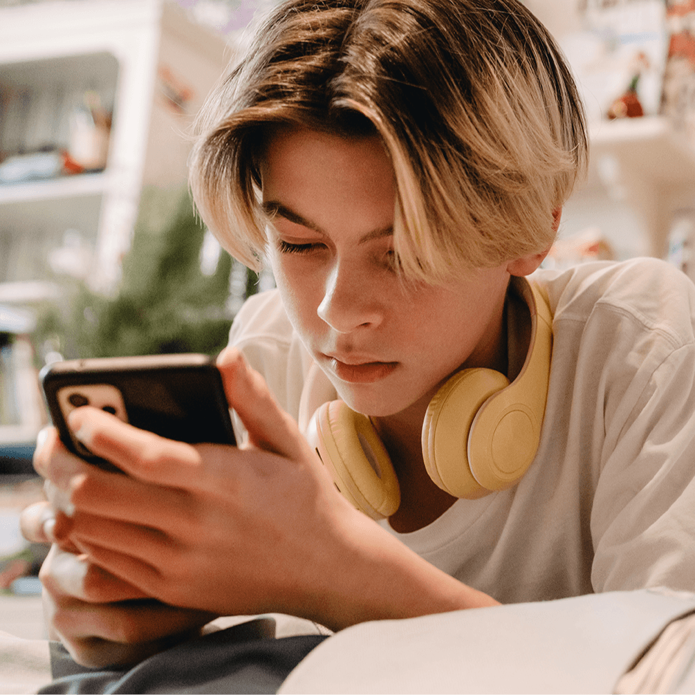 teen in bedroom looking at phone