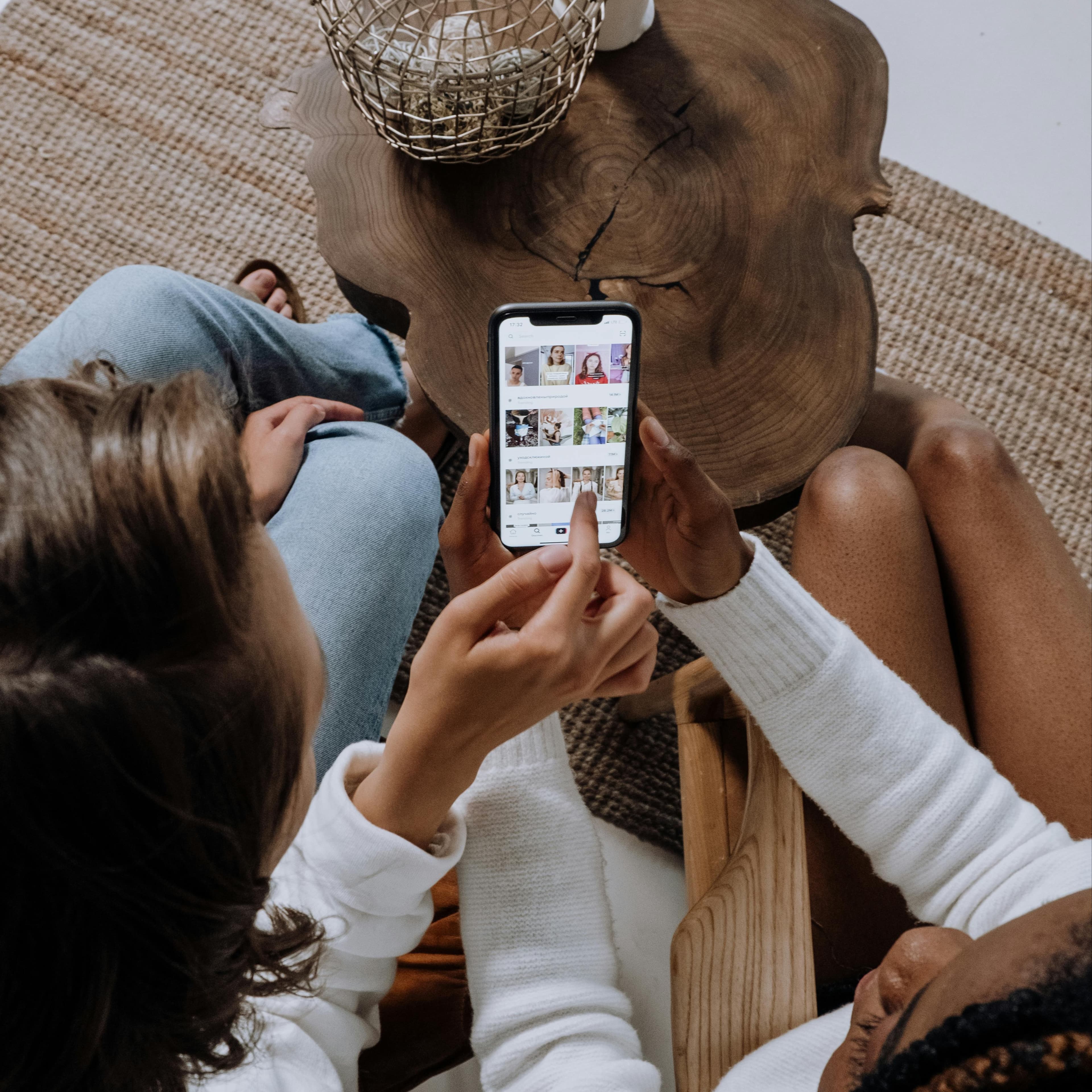 View from above as two young women look at one phone screen together