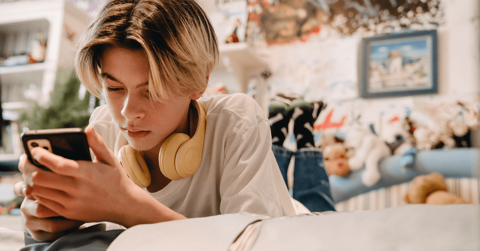 teen in bedroom looking at phone